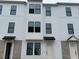 New construction townhome exterior featuring white siding, modern windows, and individual entryways at 15089 Grove Lake Dr, Winter Garden, FL 34787