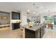 Open kitchen with a large granite island, stainless steel appliances, and modern pendant lighting at 15420 Southern Martin St, Winter Garden, FL 34787