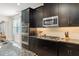 Modern kitchen featuring dark cabinets, granite countertops, stainless steel appliances, and tile backsplash at 15420 Southern Martin St, Winter Garden, FL 34787