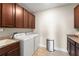 Functional laundry room equipped with modern appliances, ample counter space, and wooden cabinetry at 15420 Southern Martin St, Winter Garden, FL 34787