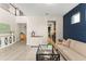 Open-concept living space with hardwood floors, blue accent wall, and contemporary furniture at 15420 Southern Martin St, Winter Garden, FL 34787