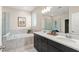 Elegant bathroom featuring double vanity, soaking tub, and glass-enclosed shower at 15420 Southern Martin St, Winter Garden, FL 34787