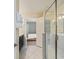 Modern bathroom featuring marble tile, vanity with dark cabinets and glass enclosed shower at 1575 Plunker Dr, Davenport, FL 33896