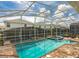 The backyard contains a screened-in pool and spa surrounded by a brick patio at 1575 Plunker Dr, Davenport, FL 33896