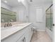 Bright bathroom featuring a vanity with quartz countertops, ceramic tile floors, and shower at 15862 Citrus Grove Loop, Winter Garden, FL 34787