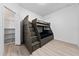 bedroom with a bunkbed with built in storage, wood-look floors, and closet at 15862 Citrus Grove Loop, Winter Garden, FL 34787