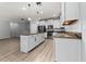 Open kitchen with stainless steel appliances, granite counters, white cabinets and wood-look floors at 15862 Citrus Grove Loop, Winter Garden, FL 34787