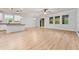 Open-concept living area with wood-look floors, abundant natural light, and access to the kitchen at 15862 Citrus Grove Loop, Winter Garden, FL 34787
