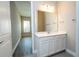Bathroom with a large mirror over a white vanity, tile floors, and doorway leading into the bedroom at 16103 Silver Brook Way, Winter Garden, FL 34787