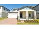 Charming single-story home featuring a spacious two-car garage and inviting covered front porch with stone accents at 16103 Silver Brook Way, Winter Garden, FL 34787