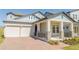 Charming home featuring a spacious two-car garage and inviting covered front porch with stone accents at 16103 Silver Brook Way, Winter Garden, FL 34787