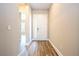 Inviting hallway with wood-look floors leading to a bright, white front door with sidelight window at 16103 Silver Brook Way, Winter Garden, FL 34787