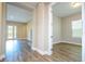 Living room area featuring wood-look floors with an adjacent bedroom offering ample natural light at 16103 Silver Brook Way, Winter Garden, FL 34787