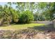 Large backyard featuring healthy green grass, mature trees, and a privacy fence at 18 Palmira Rd, Debary, FL 32713