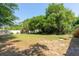 Spacious backyard with mature trees, lush grass, and a white privacy fence at 18 Palmira Rd, Debary, FL 32713