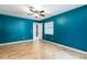 Bright bedroom featuring wood-look tile floors, a ceiling fan, and a fresh coat of blue paint at 18 Palmira Rd, Debary, FL 32713