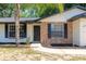 Charming home exterior featuring a brick facade, black shutters, and a well-maintained lawn at 18 Palmira Rd, Debary, FL 32713