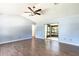 Open living room featuring wood-look tile flooring, neutral walls, and a sliding door to a screened porch at 18 Palmira Rd, Debary, FL 32713