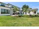 Expansive backyard with lush lawn, tropical landscaping, pool, and covered patio for outdoor enjoyment at 1891 Lake Spier Dr, Winter Park, FL 32789