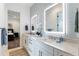 Modern bathroom featuring double sinks, marble countertops, backlit mirrors, and blue decor at 1891 Lake Spier Dr, Winter Park, FL 32789