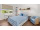 Cozy bedroom with a blue bedspread, desk, chair, and scenic lake view from the window at 1891 Lake Spier Dr, Winter Park, FL 32789