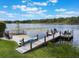 Lakeside with a private dock, seating, and a sandy beach area perfect for relaxing by the water at 1891 Lake Spier Dr, Winter Park, FL 32789