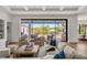 Spacious living room leading to an outdoor patio, showcasing upscale furniture and serene water views at 1891 Lake Spier Dr, Winter Park, FL 32789