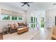 Comfortable living room with a brown sofa, neutral rug, and bright natural light from large windows overlooking the scenery at 1891 Lake Spier Dr, Winter Park, FL 32789