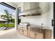 Well-equipped outdoor kitchen with stainless steel grill, ample counter space, and scenic waterfront view at 1891 Lake Spier Dr, Winter Park, FL 32789