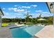 Sparkling pool with a built-in spa, sun loungers, and scenic lake views surrounded by tropical landscaping at 1891 Lake Spier Dr, Winter Park, FL 32789