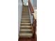 Carpeted staircase with a wooden handrail and decorative iron spindles at 2157 Island Walk Dr, Orlando, FL 32824