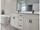 Modern bathroom with a dual-sink vanity, a soaking tub, and contemporary fixtures, exuding spa-like comfort at 2333 Sw 147Th Pl Rd, Ocala, FL 34473
