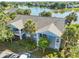 Scenic aerial view of a condo building near a tranquil lake, framed by mature trees and well-maintained lawns at 2501 Grassy Point Dr # 103, Lake Mary, FL 32746