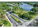 Scenic aerial view of the community entrance with lush landscaping and a serene lake in the background at 2501 Grassy Point Dr # 103, Lake Mary, FL 32746