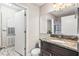 Bathroom featuring an granite vanity top, modern lighting, and a convenient walk-in shower at 2501 Grassy Point Dr # 103, Lake Mary, FL 32746