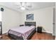Bedroom with hardwood floors, two nightstands, ceiling fan, and large wall picture at 2501 Grassy Point Dr # 103, Lake Mary, FL 32746