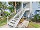 White exterior staircase leading to a condo entrance with a well-kept landscape and a charming pathway at 2501 Grassy Point Dr # 103, Lake Mary, FL 32746