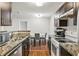 Well-lit kitchen showcases wood cabinets, granite counters, and stainless-steel appliances at 2501 Grassy Point Dr # 103, Lake Mary, FL 32746