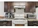 Kitchen featuring granite countertops, dark wood cabinets, and stainless steel appliances at 2501 Grassy Point Dr # 103, Lake Mary, FL 32746