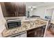 Updated kitchen with stainless steel appliances, granite countertops, and dark wood cabinetry at 2501 Grassy Point Dr # 103, Lake Mary, FL 32746