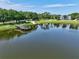 Scenic pond view featuring a gazebo on a dock, surrounded by lush greenery and blue skies at 2501 Grassy Point Dr # 103, Lake Mary, FL 32746