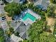 Aerial shot of a community pool and hot tub surrounded by trees and ample lounging space at 2501 Grassy Point Dr # 103, Lake Mary, FL 32746