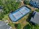 Aerial view of the blue tennis court surrounded by mature trees and residential buildings at 2501 Grassy Point Dr # 103, Lake Mary, FL 32746