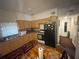 Functional eat-in kitchen featuring wood cabinets and black appliances at 2506 Perrine Pl, Orlando, FL 32808