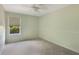 This carpeted bedroom has neutral paint, a ceiling fan, and a window with natural light at 3300 Se 22Nd Ave, Ocala, FL 34471