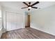 Bedroom featuring wood-look tile flooring, ceiling fan, and ample closet space at 3300 Se 22Nd Ave, Ocala, FL 34471