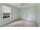 This carpeted bedroom has neutral paint, a ceiling fan, and a window with natural light at 3300 Se 22Nd Ave, Ocala, FL 34471