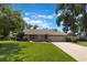 Charming one-story home features a well-manicured lawn, mature trees, and a neutral exterior color scheme at 3300 Se 22Nd Ave, Ocala, FL 34471