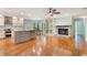 Modern kitchen featuring a central island, updated appliances, a cozy fireplace, and hardwood floors at 3300 Se 22Nd Ave, Ocala, FL 34471
