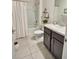 Well-lit bathroom featuring a tub and shower combination with a white shower curtain and dark cabinets at 3329 Royal Tern Dr, Winter Haven, FL 33881
